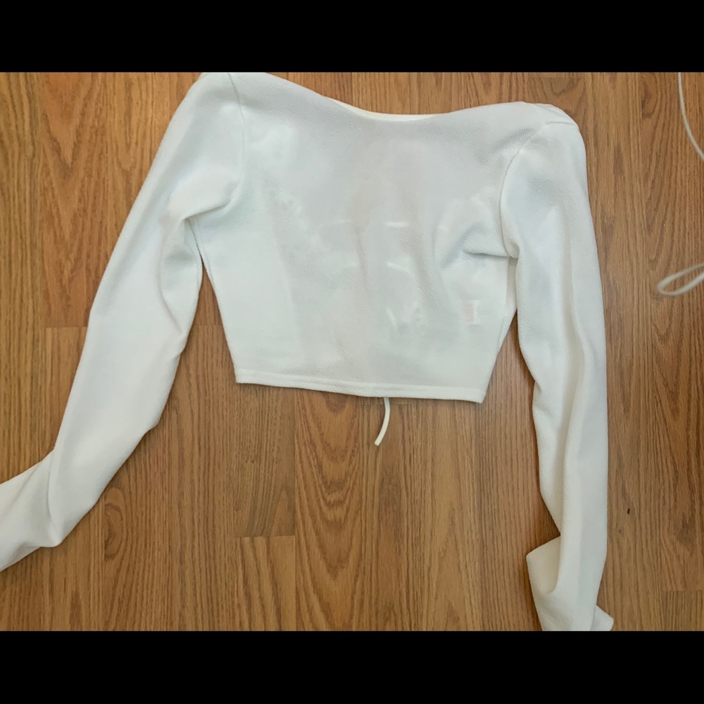 White, long sleeve crop top. Open lace back.